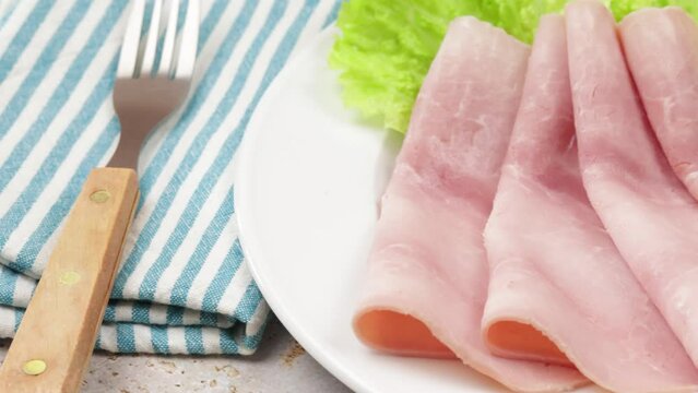 plusieurs tranches de jambon dans une assiette