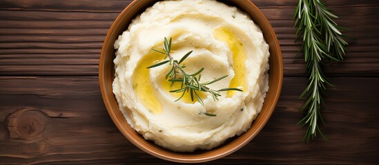 Mashed potato with rosemary and olive oil on wooden table Copy space image Place for adding text or design