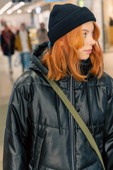 Youthful Confidence: Vertical Portrait of Teenage Girl with Red Hair in Black Hat and Jacket