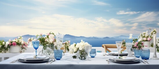 Roof holds flower adorned tables with white cloth porcelain and blue glasses Copy space image Place for adding text or design - obrazy, fototapety, plakaty