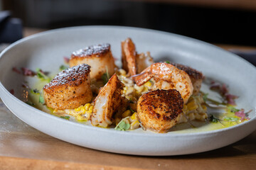 Seared scallops and shrimp on a bed of succotash.