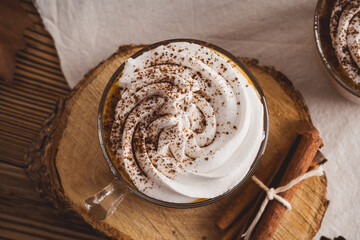 Pumpkin spice latte with whipped cream and cinnamon, warmer autumn and winter hot drink