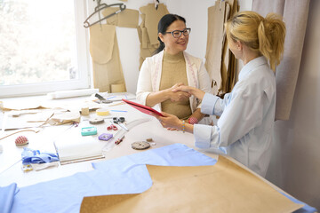 Ladies fashion designers greet each other at the workplace