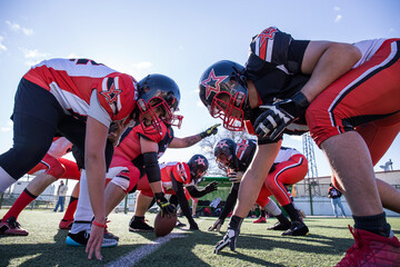 American football players on the line of scrimmage during a match