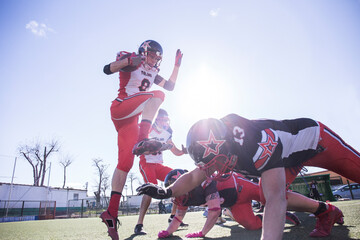 American football player jumping with the ball during a match