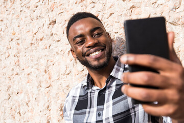Portrait of smiling young man taking selfie with cell phone