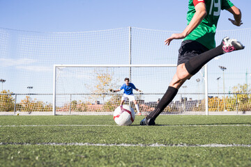 Football player shooting the ball on football field