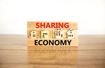 Sharing economy symbol. Concept words Sharing economy on beautiful wooden blocks. Beautiful wooden table white background. House model. Business sharing economy concept. Copy space.
