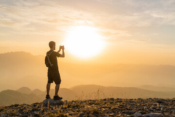 Spain, Barcelona, Natural Park of Sant Llorenc, man hiking and taking a picture of the view at...