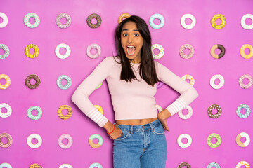 Young woman screaming at an indoor theme park with donuts at the wall