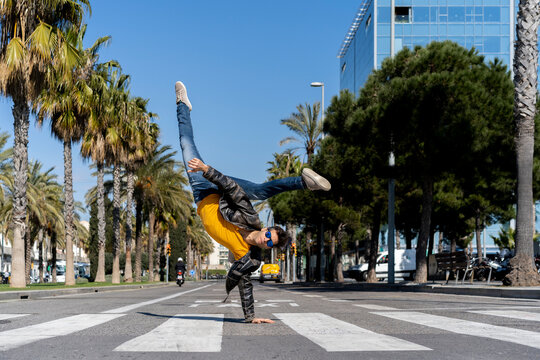 Spain, Barcelona, man in the city doing a handstand on the street