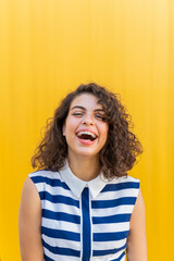 Portrait of happy young woman, yellow background