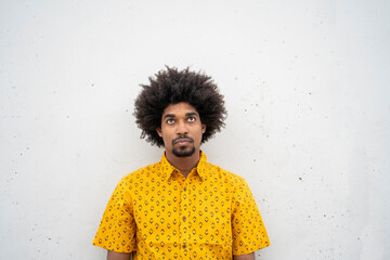 Young hipster wearing yellow shirt, looking up