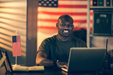 Smiling young soldier working in military base looking at camera
