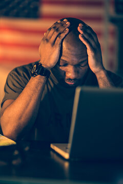 Stressed Military Man with Laptop at American Flag Background
