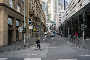 Woman with bicycle crossing street in the city, Frankfurt, Germany - obrazy, fototapety, plakaty