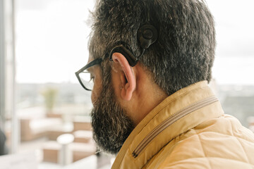 Profile of a man with cochlear implant - obrazy, fototapety, plakaty