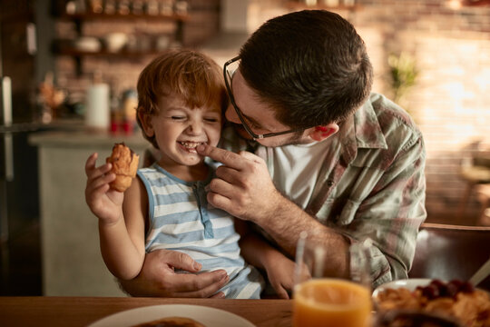 Father and Son Enjoying a Playful Breakfast Together at Home