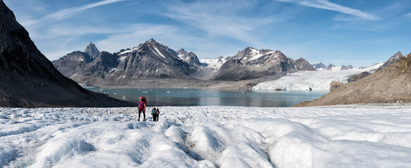 Greenland, Sermersooq, Kulusuk, Schweizerland Alps, group of people walking in snow - obrazy, fototapety, plakaty