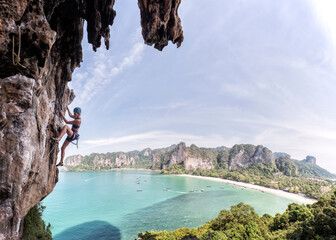 Thailand, Krabi, Thaiwand wall, woman climbing in rock wall above the sea