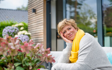Portrait of smiling woman relaxing on terrace at home
