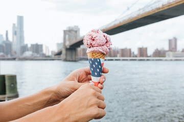 USA, New York City, Brooklyn, close-up of woman at the waterfront holding an ice cream cone