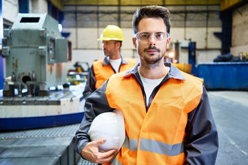 Portrait of serious man wearing protective workwear in factory