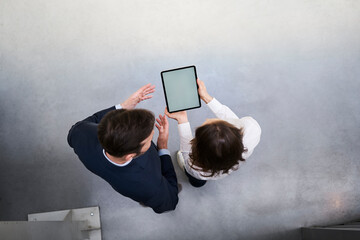 Top view of businessman and woman with tablet talking in a factory