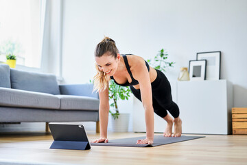 Woman learning exercise on internet through digital tablet at home