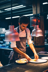 Chef serving food on plates in the kitchen of a restaurant