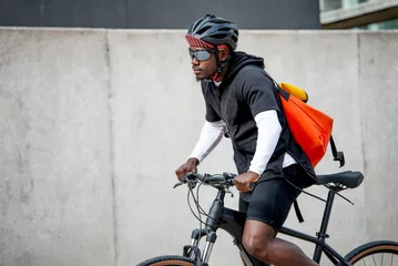 Foto auf Acrylglas Stylish young man with messenger bag riding bicycle in the city © tunedin