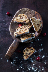 Sliced Christmas Stollen with icing sugar on a wooden scoop