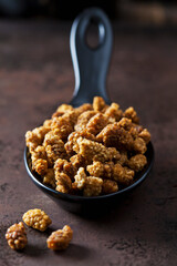 Spoon of dried mulberries on rusty metal