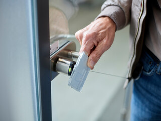 Close-up of businessman in office opening door with access card