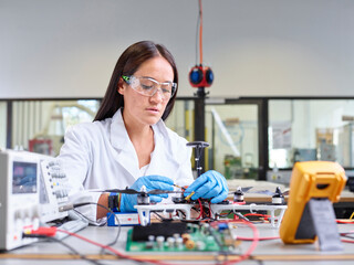 Female technician working in research laboratory, connecting plug of drone