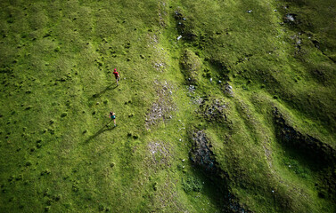 Man and woman running in the mountains, drone view