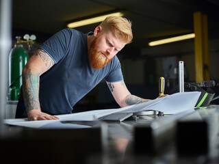 Male professional analyzing business plan while standing at factory