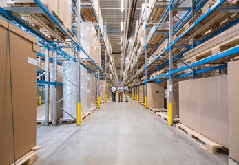 Three men standing in factory warehouse