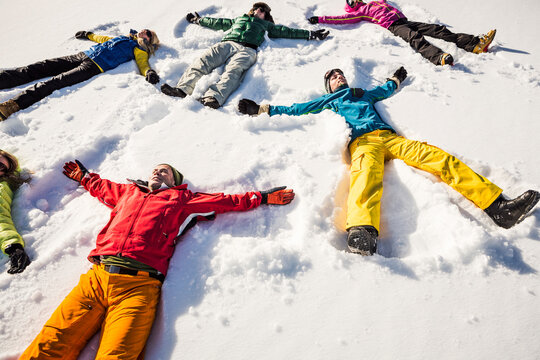 Group of friends lying in snow