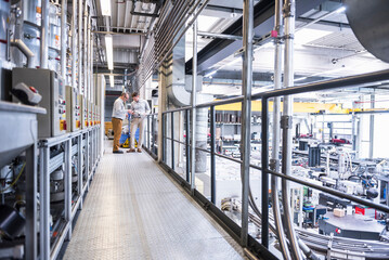 Two men talking in factory shop floor