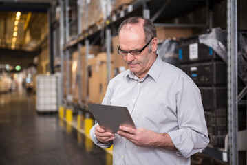Man using tablet in factory warehouse