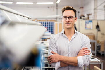 Portrait of smiling young businessman in factory