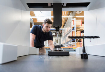 Man examining machine in modern factory