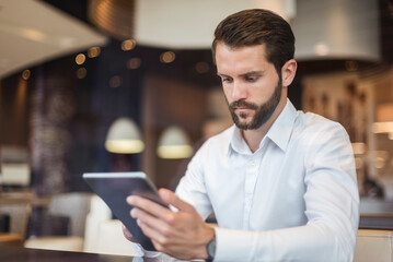 Young businessman using tablet in a cafe