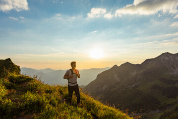Germany, Bavaria, Oberstdorf, man on a hike in the mountains at sunset