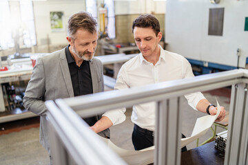 Two businessmen discussing plan in a factory