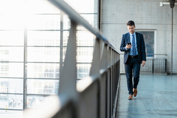 Businessman with cell phone on the move