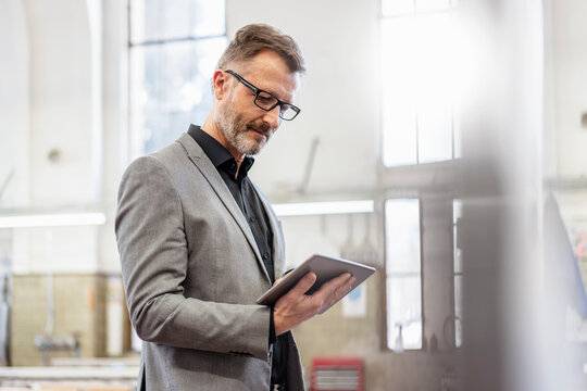 Businessman using tablet in a factory