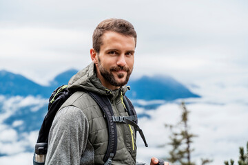 Portrait of confident young man on a hiking trip in the mountains, Herzogstand, Bavaria, Germany