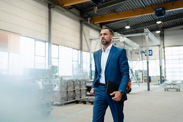 Businessman walking in a factory